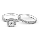 Showcasing a dazzling halo, this contemporary white gold wedding set is highlighted by .45 ctw of arresting round cut white diamonds.
