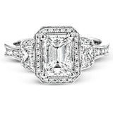 Featuring a lovely romantic setting, this white gold contemporary ring features an exquisite halo and .33 ctw of shimmering round cut white diamonds complemented by .34 ctw of trapezoid side diamonds.