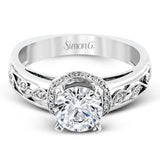 Set with delicate floral patterns, this classic white gold engagement ring is highlighted with .12 ctw round cut white diamonds.