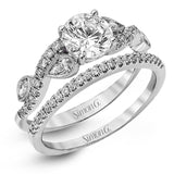 Featuring a distinctively romantic design, this white gold engagement ring and band are set with .22 ctw of round cut white diamonds, .09 ctw of marquise cut diamonds, and .13 ctw pear-shaped diamonds.