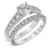 Elevating a classic design with modern elements, this exquisite white gold engagement ring and band are emphasized by .77 ctw of sparkling round cut white diamonds.