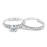 Elevating a classic design with modern elements, this exquisite white gold engagement ring and band are emphasized by .77 ctw of sparkling round cut white diamonds.