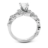 This delicate floral inspired white gold engagement ring and wedding band set is accentuated with .28 ctw shimmering round cut white diamonds.