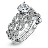 This delicate floral inspired white gold engagement ring and wedding band set is accentuated with .28 ctw shimmering round cut white diamonds.