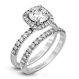 This elegant classic white gold halo engagement ring and band is set with .78 ctw of sparkling round cut white diamonds.