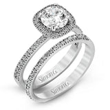 Accented by .46 ctw of glistening round cut white diamonds, this contemporary white gold halo style engagement ring and wedding band set makes a dramatic statement.