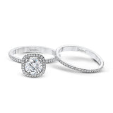 Accented by .46 ctw of glistening round cut white diamonds, this contemporary white gold halo style engagement ring and wedding band set makes a dramatic statement.