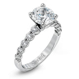 This marvelous white gold wedding set highlights its center stone with 1.19 ctw of round white diamond accents.