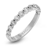 This marvelous white gold wedding set highlights its center stone with 1.19 ctw of round white diamond accents.