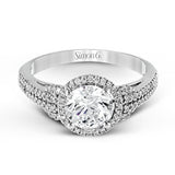 This 18k white gold ring contains .30 ctw of side diamonds set within its classic halo design.