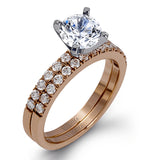 Featuring a modern take on a classic design, this white gold engagement ring and wedding band are inset with .58 ctw of glimmering round cut white diamonds.