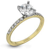 Featuring a modern take on a classic design, this white gold engagement ring and wedding band are inset with .58 ctw of glimmering round cut white diamonds.