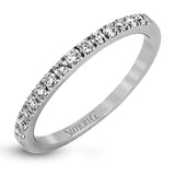Featuring a modern take on a classic design, this white gold engagement ring and wedding band are inset with .58 ctw of glimmering round cut white diamonds.