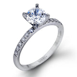 Featuring a modern take on a classic design, this white gold engagement ring and wedding band are inset with .58 ctw of glimmering round cut white diamonds.