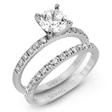 Featuring a modern take on a classic design, this white gold engagement ring and wedding band are inset with .58 ctw of glimmering round cut white diamonds.