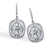 These exquisite vintage-inspired 18k white gold earrings contain delicate filigree and 1.12 ctw of white diamonds surrounding a gorgeous 7.12 ctw of green tourmaline.