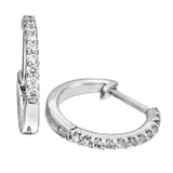 Featuring a classic hoop style with modern accents, these sparkling white gold earrings are accentuated by .17 ctw of round cut white diamonds.