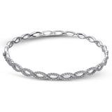 These simple twisted 18k gold bangle is the perfect accent piece. It can be worn alone or stacked with others, and has 1.12 ctw of white diamonds.