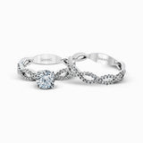 The intricate twisted design of this modern white gold engagement ring and wedding band set is set with .65 ctw of striking round cut white diamonds.