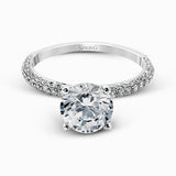 Presenting an eye-catching modern design, this white gold engagement ring and wedding band are highlighted by 1.45 ctw of round cut white diamonds.