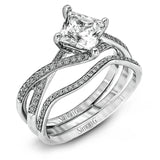 This dramatic white gold engagement ring and wedding band set are highlighted by .23 ctw of dazzling round cut white diamonds in a distinctive modern twist design.