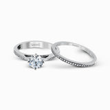 The elegant design of this classic white gold engagement ring and wedding band is complemented by .21 ctw of glimmering round cut white diamonds.