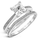 Featuring a simple, elegant classic design, this white gold engagement ring and wedding band is set with .16 ctw of round cut white diamonds.