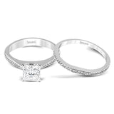 Featuring a simple, elegant classic design, this white gold engagement ring and wedding band is set with .16 ctw of round cut white diamonds.