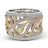 This vintage inspired tri-tone band features a delicate floral design accented by .55 ctw round cut white diamonds and .20 ctw round cut yellow diamonds set in lovely rose, yellow, and white gold.