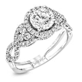 Reflecting an intricate modern design, this remarkable white gold ring is emphasized by a lovely halo complemented with .59 ctw round cut white diamonds.