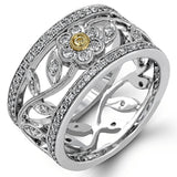 This charming white gold vintage style ring features a lovely floral design accented by .77 ctw of round cut white diamonds and .02 ctw round cut yellow diamonds.