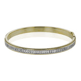 A striking 18K bangle in two-tone gold with a row of baguette diamonds 2.0 ctw. set in white gold, with a delicate ribbed edge