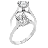 This elegant white gold engagement ring takes an Emerald center and is adorned with a delicate under halo, and a line of diamonds on the side profile 0.13 ctw