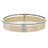 Stunning two-tone wide bangle in rose gold has a brushed finish and features a cluster of princess cut diamonds 0.43 ctw in its center, with a row of round brilliant diamonds 0.39 ctw. along the edge
