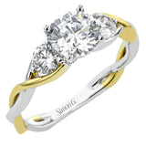 This 18K three stone ring in two-tone gold has a delicate twist design with a polished yellow gold side and a polished white gold side. The center is highlighted by two RD diamonds.