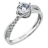 This criss-cross design engagement ring shimmers with 0.15 ctw round diamonds and a halo of gold strands wrapped around the center