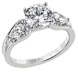 This modern 3 stone engagement ring takes a Round center and is flanked by 2 pear shaped diamonds 0.36 ctw., and 0.06 ctw of round diamonds