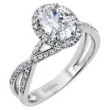 This sparkling modern engagement ring features an eye-catching twisted design with elegant classic halo accented by .29 ctw of shimmering round cut white diamonds.