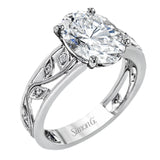 A delicate floral design highlights this vintage style engagement ring accented by .09 ctw of shimmering round cut white diamonds.