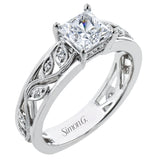 A delicate floral design highlights this vintage style engagement ring accented by .09 ctw of shimmering round cut white diamonds.