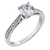 Sleek and lovely, this white gold engagement ring has an elegant design enhanced with .14 ctw of round white diamonds.