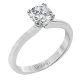This sleek, unadorned white gold ring provides an elegantly modern setting for a single, central stone.