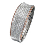 Offering a distinctive contemporary style, this bangle bracelet is white and rose gold is accented by an astounding 18.85 ctw princess cut white diamonds and .79 round pink diamonds.