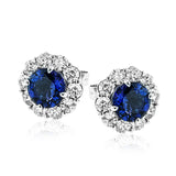 These lovely, vintage-inspired white gold earrings feature 1.15 ctw of sapphires framed by halos containing 1.17 ctw of round white diamonds.