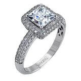 This vintage-inspired 18k white gold engagement ring is the perfect design for princess cut center stone because it has a detailed square shaped halo. The entire ring is set with .62 ctw of white diamonds.