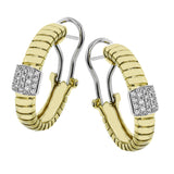 This elegant huggie earring in 18K yellow gold has a ribbed design and accented with 0.24 ctw. of pave set diamonds in white gold, and a lever back closure