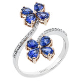 This floral inspired fahion ring shines with a swirl of diamonds 0.18 ctw. in 18K white gold, and has 2 blooms at the ends, with petals made of pear-shaped sapphires 1.90 ct. set in rose gold