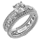 This wedding set features a white gold vintage inspired engagement ring in the center with a yellow gold granulated ring guard that provides a unique look.
