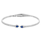 This modern hinged bangle adds a touch of color with two precious gemstone accent, set off by .30 ctw of white diamonds along the sides.