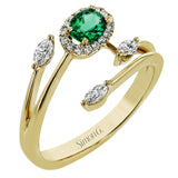 This delightful 18k white and yellow gold ring is set with one .25 ctw emerald and .06ctw of white diamonds and .16ctw marquise diamonds in its bypass design